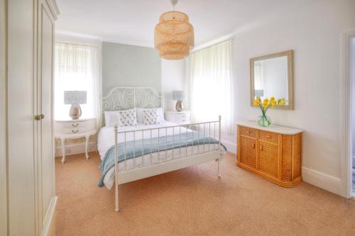 ein Schlafzimmer mit einem Bett, einem Spiegel und einer Kommode in der Unterkunft Seaside spacious 4 BR Nr Town centre and Open Golf in West Kirby
