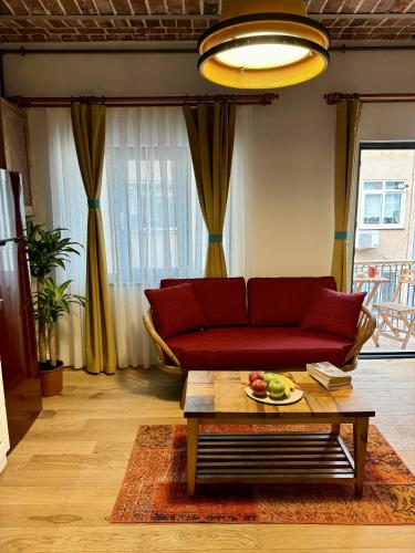 a living room with a red couch and a table at Heristage Istanbul Galataport in Istanbul