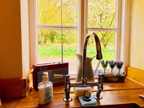 a kitchen counter with a sink and a window at Gamekeepers Cottage, hot tub & open fire. in Gaywood