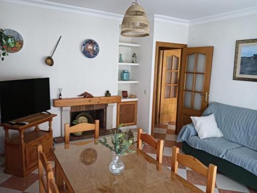uma sala de estar com um sofá e uma mesa em Casa Delfin em Punta Umbría
