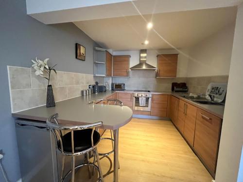 a kitchen with a white table and some chairs at Plush Apartment 2 bed for Business and Pleasure in Wakefield