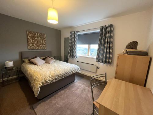 a small bedroom with a bed and a window at Plush Apartment 2 bed for Business and Pleasure in Wakefield