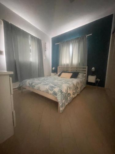 a bedroom with a bed with a blue wall at B&B Villa Luna in Bayahibe