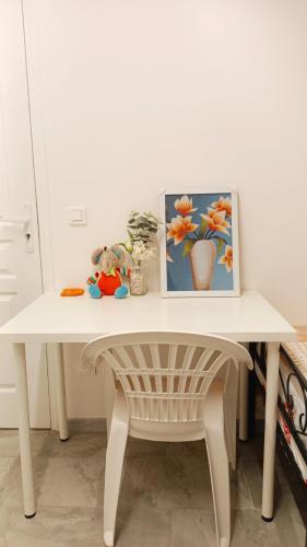 une table blanche avec une photo et une chaise dans l'établissement Bienvenue à PARIS - Appartement confortable, grande terrasse privée au calme, parking gratuit, à Vitry-sur-Seine