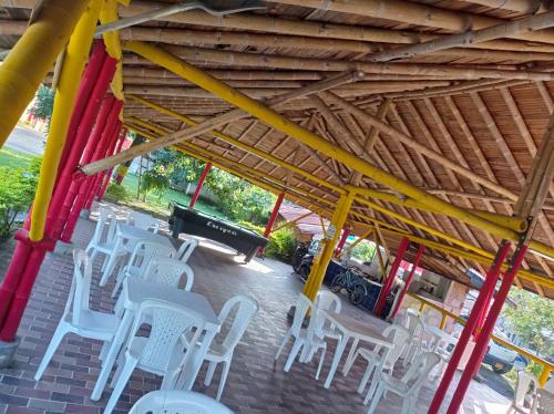 a group of white chairs and a piano at Hotel flamingo real T in Mariquita