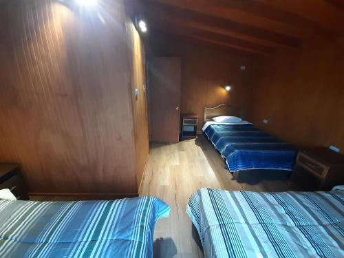a room with two beds on a boat at Cabañas Raulies, Neltume. in Puerto Fuy