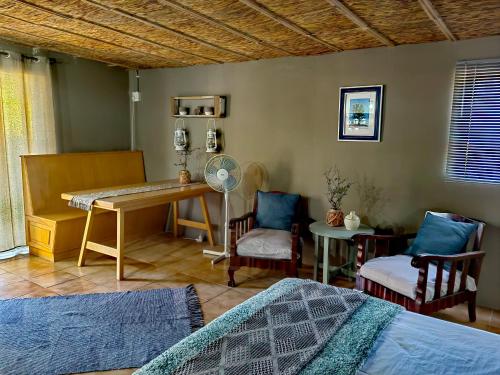 1 dormitorio con 2 camas, escritorio y sillas en Duiker's self catering Accommodation en Askham