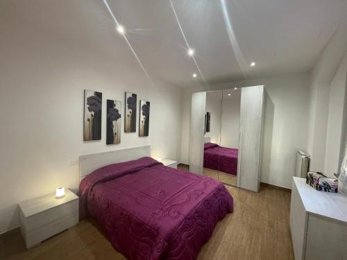 B&B L'Antico Portone في كاسيلّي تورينيسي: غرفة نوم مع سرير أرجواني ومرآة