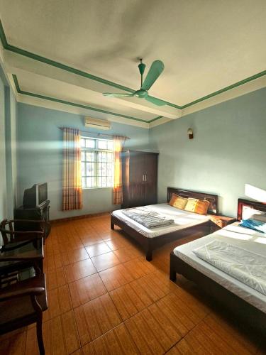 a bedroom with two beds and a ceiling fan at Nhà Nghỉ Thái Thu in Cao Bằng