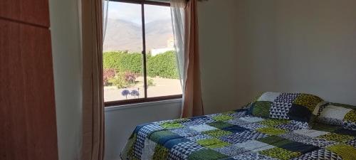 にあるFogones del Valleのベッドルーム1室(ベッドに掛け布団付)、窓が備わります。