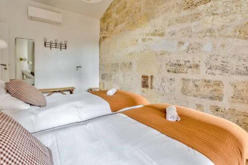 two beds in a room with a brick wall at Nocnoc - Le Balcon de l'Oli 99m2 in Bordeaux