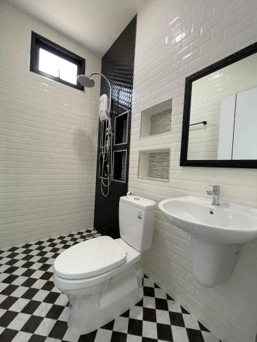 a bathroom with a white toilet and a sink at Baan pakiet&Khun jang in Ban Nam Lai Ta Tum