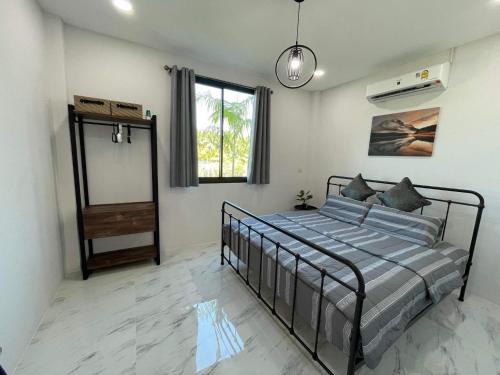 um quarto com uma cama e uma janela em Baan pakiet&Khun jang em Ban Nam Lai Ta Tum