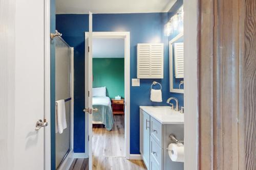 a blue bathroom with a sink and a bed at Bee Branch 44 in Sugar Mountain
