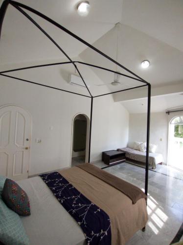 a bedroom with a bed with a glass canopy at Casa Tzunun Airport Junior Suite in Cancún