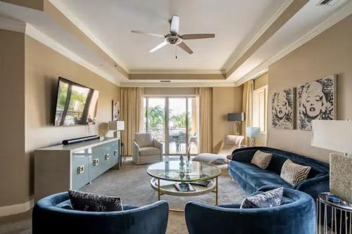 a living room with blue furniture and a ceiling fan at Ocean View Residence 304 located at The Ritz-Carlton in Upper Land