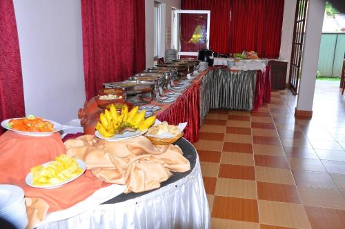 Siyanco Holiday Resort في بولوناروا: صف من طاولات البوفيه مع اطباق من الطعام