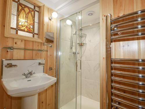 een badkamer met een wastafel en een douche bij Mill Cottage in Liskeard