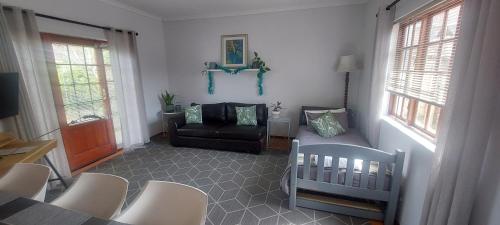 a living room with a crib and a chair at Grey-door cottage Number1 in Glendinningvale