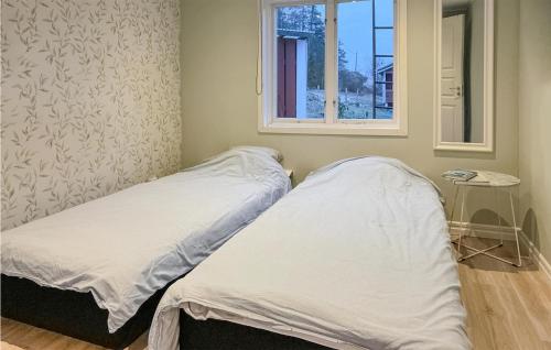 two beds in a room with a window at Gorgeous Home In Nssj With House Sea View in Nässjö