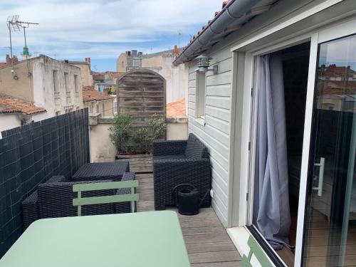 einen Balkon mit einem Tisch und Stühlen auf einem Gebäude in der Unterkunft Les Marionnettes, Maison de ville 80m2 avec terrasse in La Rochelle