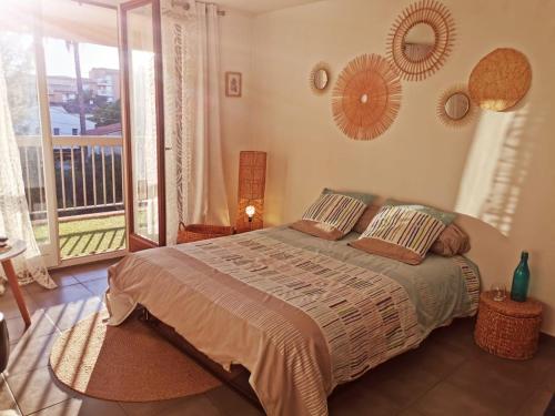 - une chambre avec un grand lit et un balcon dans l'établissement Coquillages et Crustacés, à Saint-Aygulf