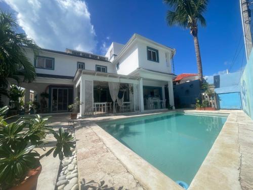 a swimming pool in front of a house at B&B Villa Luna in Bayahibe