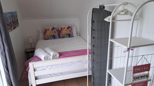 a small bedroom with a bed and a shelf at Smartie Box in Langebaan
