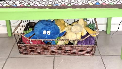 a basket of stuffed animals sitting under a table at Smartie Box in Langebaan