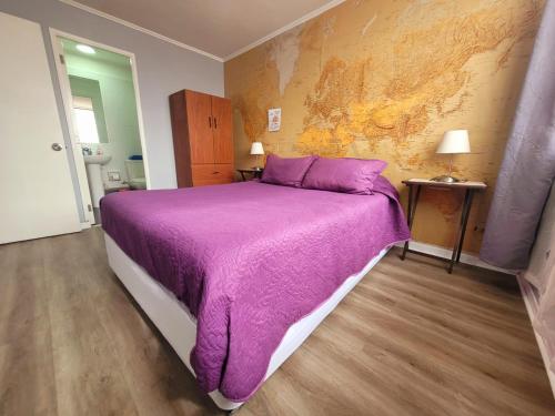 sypialnia z łóżkiem z fioletowym kocem w obiekcie ChileRuca Departamentos Amoblados w mieście Santiago