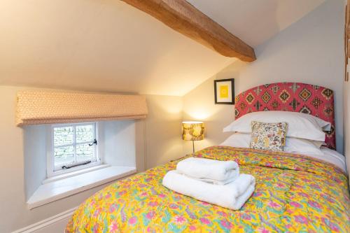 1 dormitorio con 1 cama con toallas en Micklethorn at Broughton Sanctuary, en Skipton