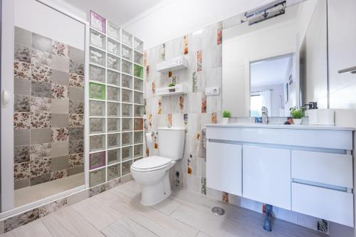 ein Badezimmer mit einem WC, einem Waschbecken und einem Spiegel in der Unterkunft O Encanto do Algarve in Carvoeiro