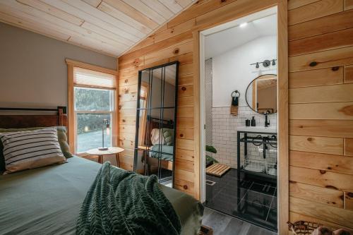 1 dormitorio con 1 cama y baño con ducha en Cabin Blhues - Countryside Escape Pond Hot Tub, en Narrowsburg