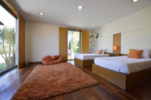a bedroom with two beds and a large window at Villa 320 in Barcelos