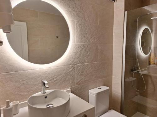 a bathroom with a sink and a toilet and a mirror at Casa Limoncello in Puerto del Carmen