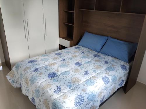 a bedroom with a bed with a blue and white comforter at Casa privativa no norte da ilha in Florianópolis