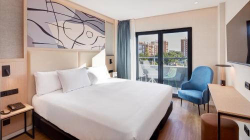 una camera d'albergo con un grande letto e una finestra di Sercotel Rosaleda Málaga a Málaga