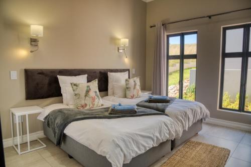 a bedroom with a large bed with a large window at Highland Gate Eagles Breeze in Dullstroom