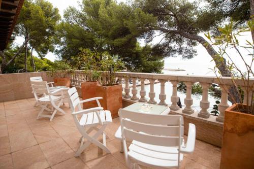 eine Gruppe von Stühlen und Tischen auf einer Terrasse mit Blick auf das Wasser in der Unterkunft Paraíso Costa Dorada in Tarragona