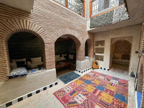 Habitación con chimenea de ladrillo y alfombra. en Riad Hna Ben Saleh, en Marrakech