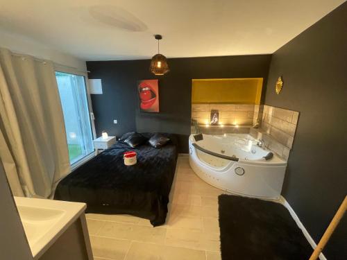 La salle de bains est pourvue d'une baignoire, d'un lit et d'un lavabo. dans l'établissement Studio M romantisme et élégance, à Pézenas