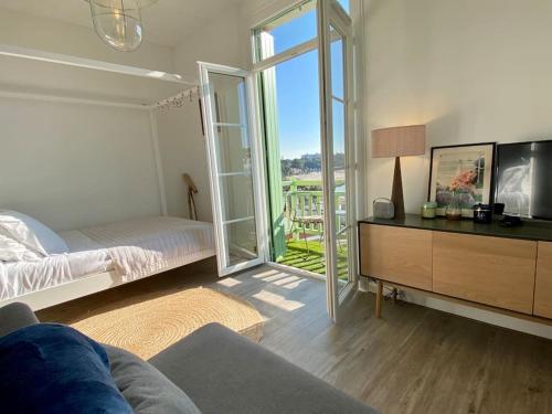 a living room with a bed and a sliding glass door at Studio lumineux vue mer et plage avec balcon in Saint-Palais-sur-Mer