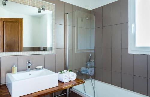 a bathroom with a sink and a shower and a tub at Villa Mare in Corbara