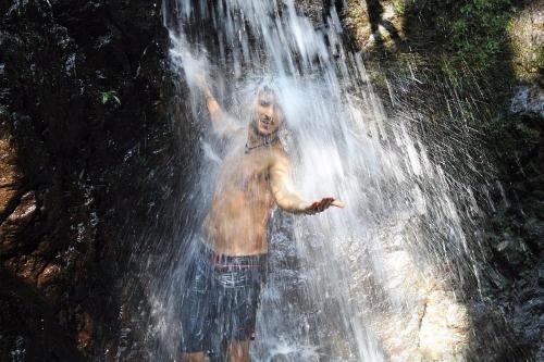 a man standing in front of a waterfall at Casa Bolita in Dos Brazos