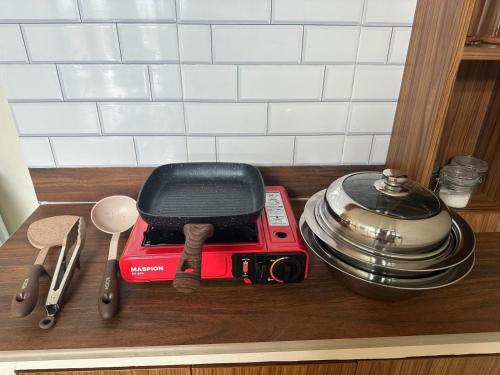 a counter top with a red toaster and utensils at Villa Takasima Berastagi in Berastagi