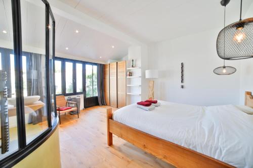 ein Schlafzimmer mit einem Bett und einem Schreibtisch in einem Zimmer in der Unterkunft Villa La Saliere in Saint-Clément-des-Baleines