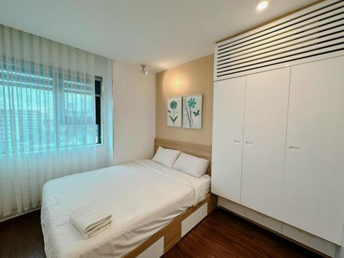 a small bedroom with a bed and a window at Muong Thanh Son Tra Apartment Seaview Da Nang in Da Nang