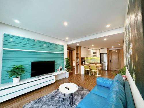 a living room with a blue couch and a tv at Muong Thanh Son Tra Apartment Seaview Da Nang in Da Nang