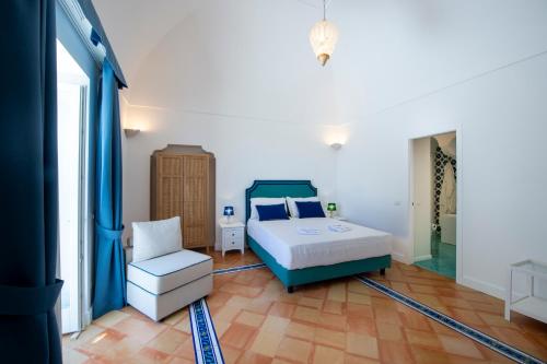 a bedroom with a bed and a chair at Casa Don Ciccio Positano in Positano