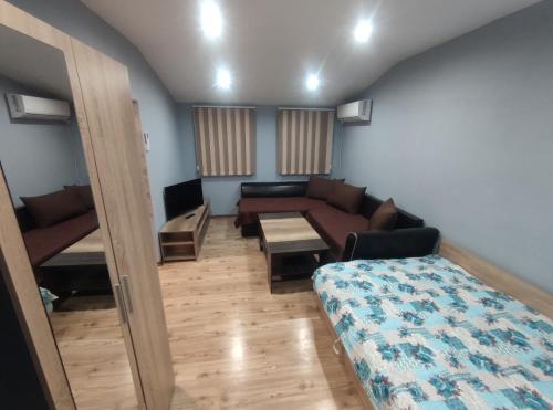 - un salon avec un canapé, un lit et une table dans l'établissement Toshevo Guests, 